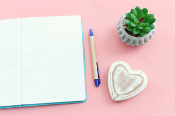 Empty open notebook and zen pebbles on pastel wooden background. copy space for text