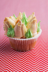 Vertical shot sweet cupcake with heartshaped flowers.