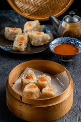 Assorted Chinese Dimsum in bamboo basket. Dimsum is a large range of small dishes that Cantonese people traditionally enjoy in restaurants for breakfast and lunch.