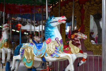 Fototapeta na wymiar merry-go-round wooden horses, Carousel Horse with traditional paintwork. Beautiful horse Christmas carousel in a holiday park. Two horses on a traditional fairground vintage carousel. Merry-go-round