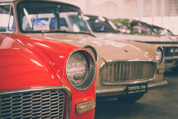 Close up round headlights of red vintage classic car. Transportation and retro car collection concept.