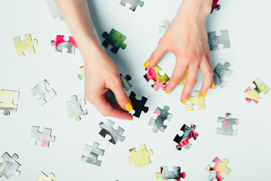 A woman with a puzzle on blue background top view