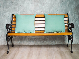 Wooden seats with green pillows placed.