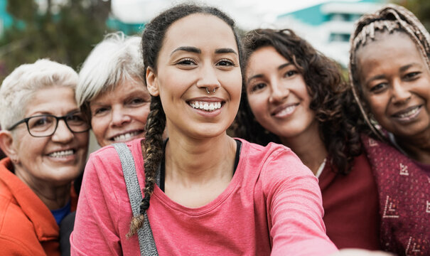 Multiracial women smiling in camera while taking a selfie at park after yoga class - Multi generational people concept