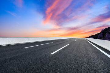Asphalt highway and colorful cloud scenery at sunrise.