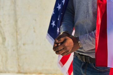 African american person with shackles in his hands and united states flag over his shoulders....
