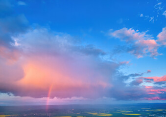 Naklejka na ściany i meble Evening, vibrant sky, pink violet blue clouds lit by setting sun. Huge rainbow over agriculture landscape. Aerial view, far horizon, ideal for sky replacement process.