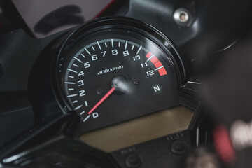 motorcycle speedometer on black background, shot from left side view