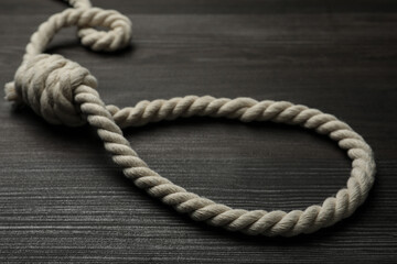 Obraz premium Rope noose on dark wooden table, closeup