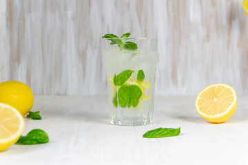glass of lemon lemonade with mint and ice on white background