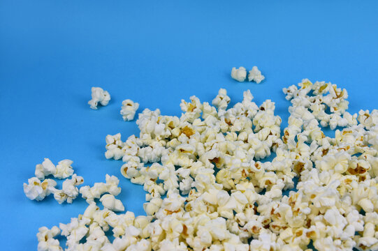 Popcorn on a blue background stock images. Spilled popcorn on a blue background with copy space for text
