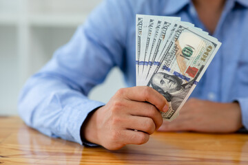 Business man hands counting US Dollar bills or paying in cash .