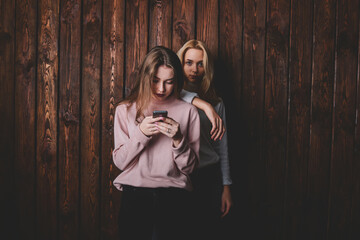 Young pensive woman leaning on shoulder of girlfriend