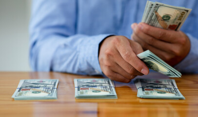 Business man hands counting US Dollar bills or paying in cash .