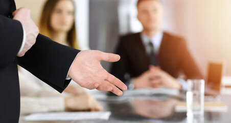 Business presentation. Businessman giving speech to colleagues and partners at corporate meeting or conference, close-up of speaker hands