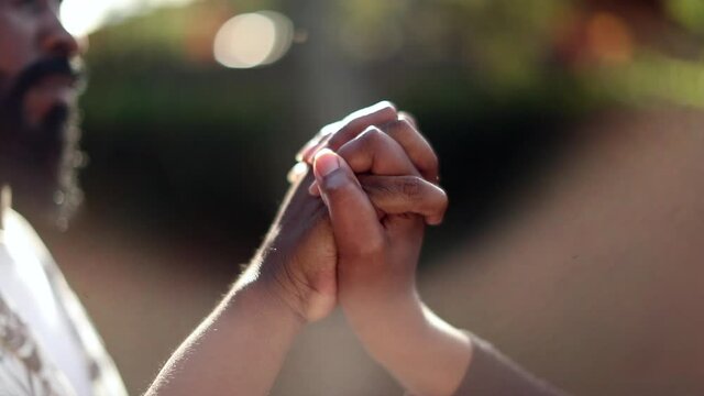 Couple joining hands in union outside with lens-flare