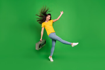 Full length body size photo girl with long brunette hair keeping boom box smiling isolated bright green color background