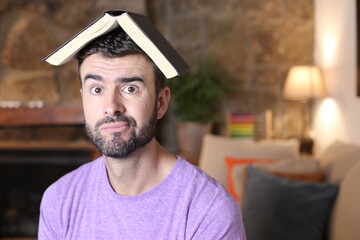 Confused man with book over head 