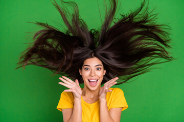 Photo of young shocked astonished woman raise hands fly hair information reaction isolated on green...
