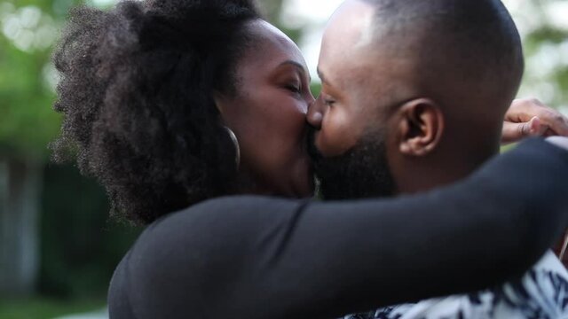 Couple kissing, african man and woman kiss outside