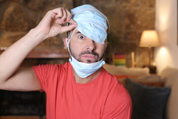 Exaggerated man covering his head with surgical masks