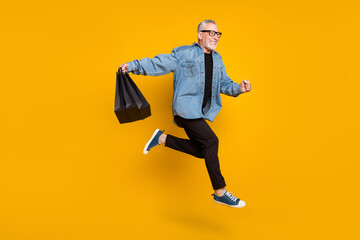 Full body profile photo of funny grandpa hold bags run wear jacket pants isolated on yellow color background