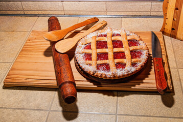 Close-up of a warm homemade Pasta Frola tart filled with quince and apple jelly. Argentinian Pastafrola Recipe on wooden table.