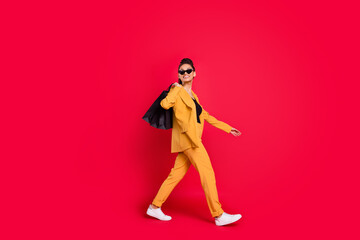 Profile full body photo of cute lady go with bags wear yellow blazer isolated on vivid red color background