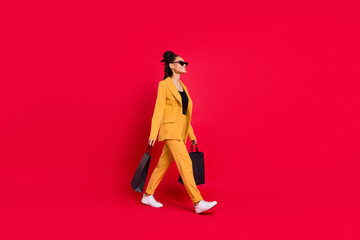 Profile full body photo of nice lady go wear yellow blazer isolated on vivid red color background