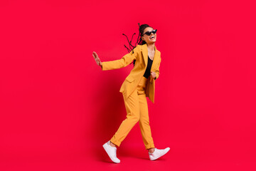 Full body profile photo of nice lady go wear eyewear yellow suit isolated on vivid red color background