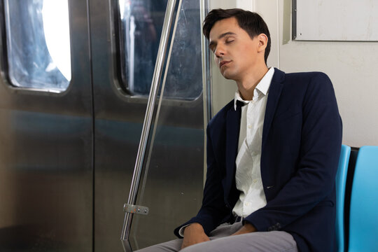 male businessman sleeping inside the subway train