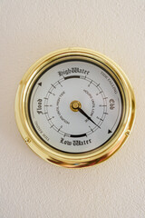 Brass tidal clock on a wall