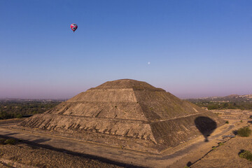 Fototapeta na wymiar Globos aerostáticos volando cerca del templo del sol de Teotihuacan en México, amanecer con la luna, azul colorido