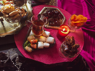 Black tea in lale with turkish delight on a purple background