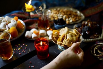 Hand with plate with figs as part of eastern sweets table