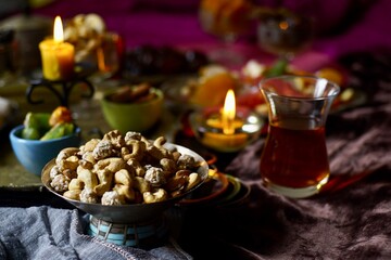 Fototapeta na wymiar Nuts mix on a black table background with candles and turk lale with tea