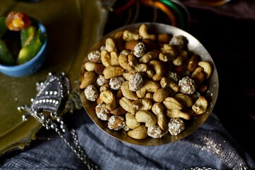 Nuts mix on a black table background with candles and turk lale with tea