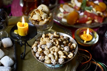 Nuts mix on a black table background with candles and turk lale with tea