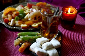 Black Turkish tea in lala with oriental sweets and dried fruits by candlelight