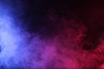 Obraz na płótnie Canvas Artifiacial magic smoke in red-blue light on black background