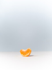 Single Slice of Orange Fruit on Light Blue and White Background