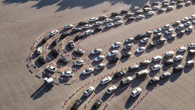 Aerial shot of 1000&rsquo;s of people in cars waiting in line at a drive-through testing site to be tested for Coronavirus or to receive the vaccine.