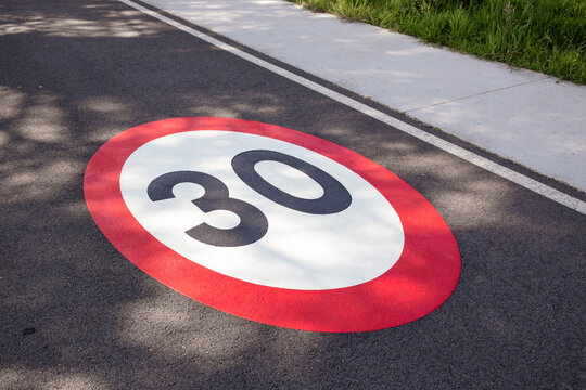 30 kilometers hour speed limit sign painted on asphalting road