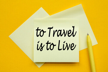 paper on yellow background with text TO TRAVEL IS TO LIVE