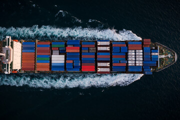 Container ship sailing fast in sea top view at night process, service and international transport...