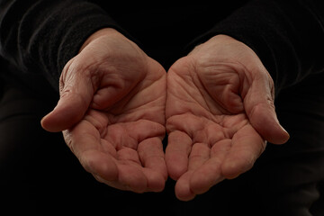 Hands of senior woman isolated on black backgound