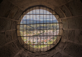 ventana circular con rejas de una iglesia, se ve la ciudad, biblian, cañar, ecuador
