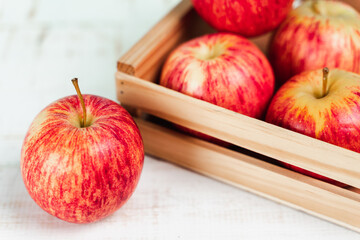 Close up of fresh ripe red apples in a wooden box.