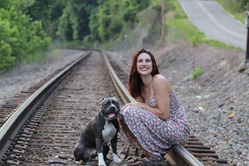 Naklejka na ściany i meble beautiful woman with pitbull dog on train tracks
