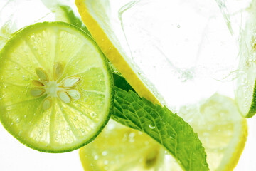 Fototapeta na wymiar Lemon and line drop in fizzy sparkling water, juice refreshment